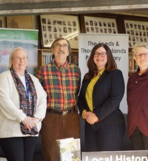 TLTI Library CEO Cindy Code, Archivist Pierre Mercier, Mayor Corinna Smith-Gatcke. Group of four people smiling for a photo