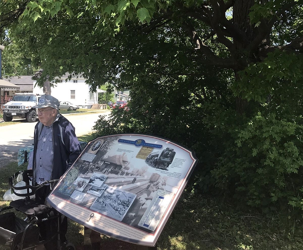 man standing by the railway heritage sign
