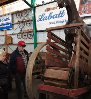 Anne & Ralph Hunt looking at the horse-powered apparatus. a couple looking at an antique horse-powered machine