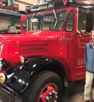Stephen Heaton waiting for the bus... man standing beside a big red bus