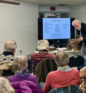 As part of Karen's presentation, long-time member Art Shaw shows some boatbuilding tools. Man presenting boatbuilding tools